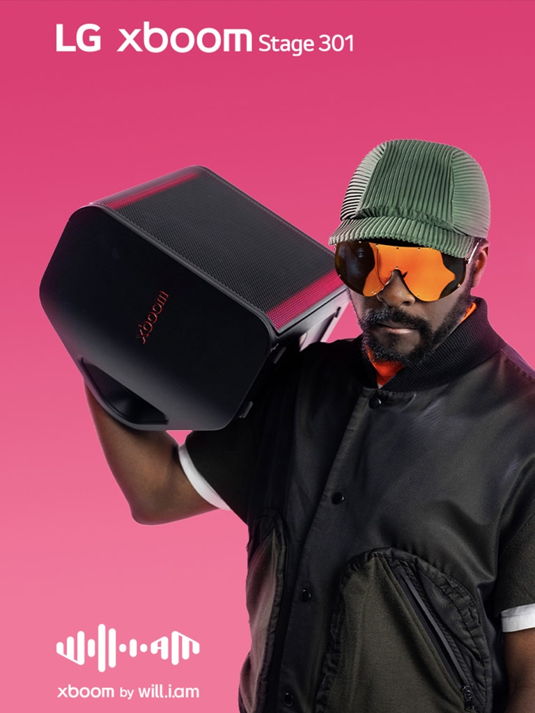will.i.am in black outfit and sunglasses is holding xboom Stage 301 on his shoulder.	