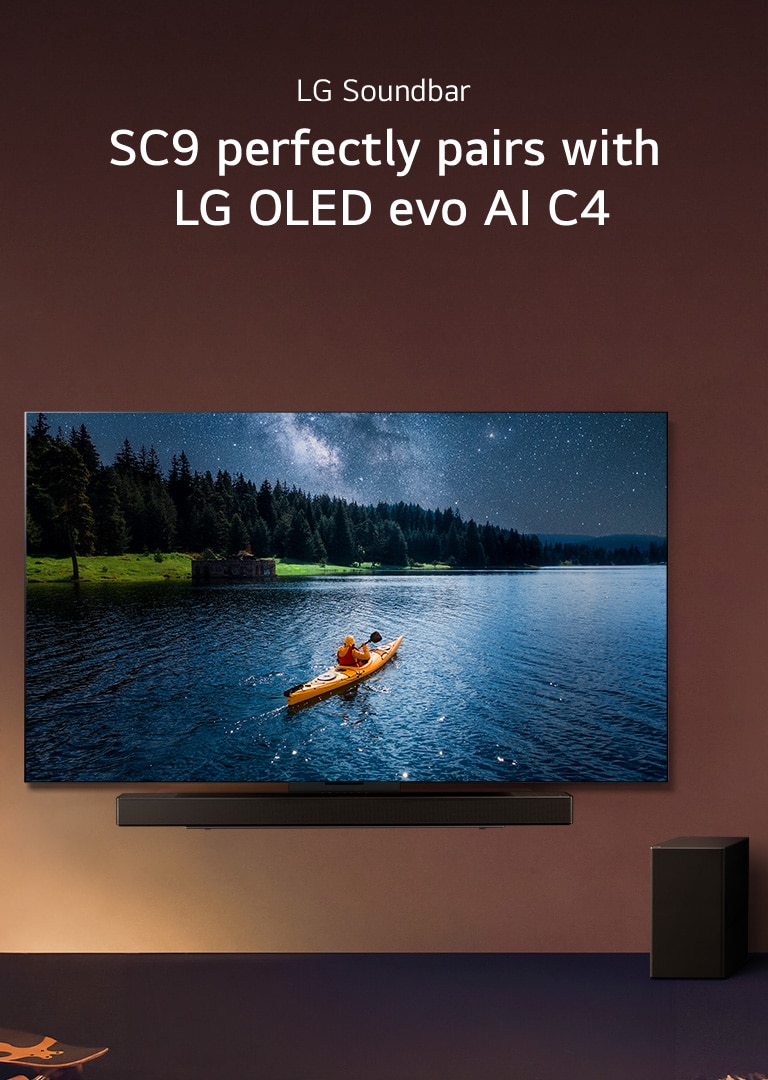 LG TV and Soundbar mounted on a wall and a suboofer on the floor to the right. On the TV, a person in a kayak on a lake is displayed, and soft shadows cascade over the wall.