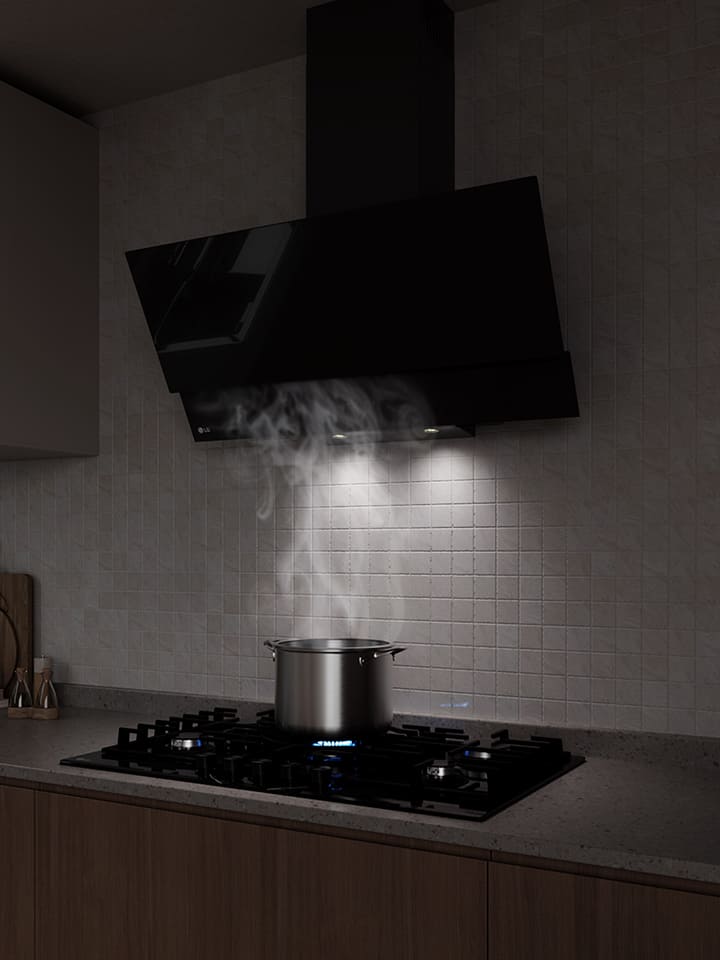 A black glass hood above a gas cooktop draws in steam rising from a pot while cooking in a modern kitchen.