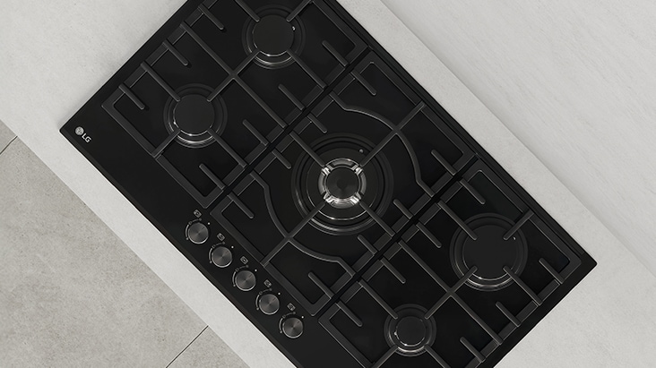 Top view of black gas cooktop with durable cast-iron grates designed for stable and secure cookware support.