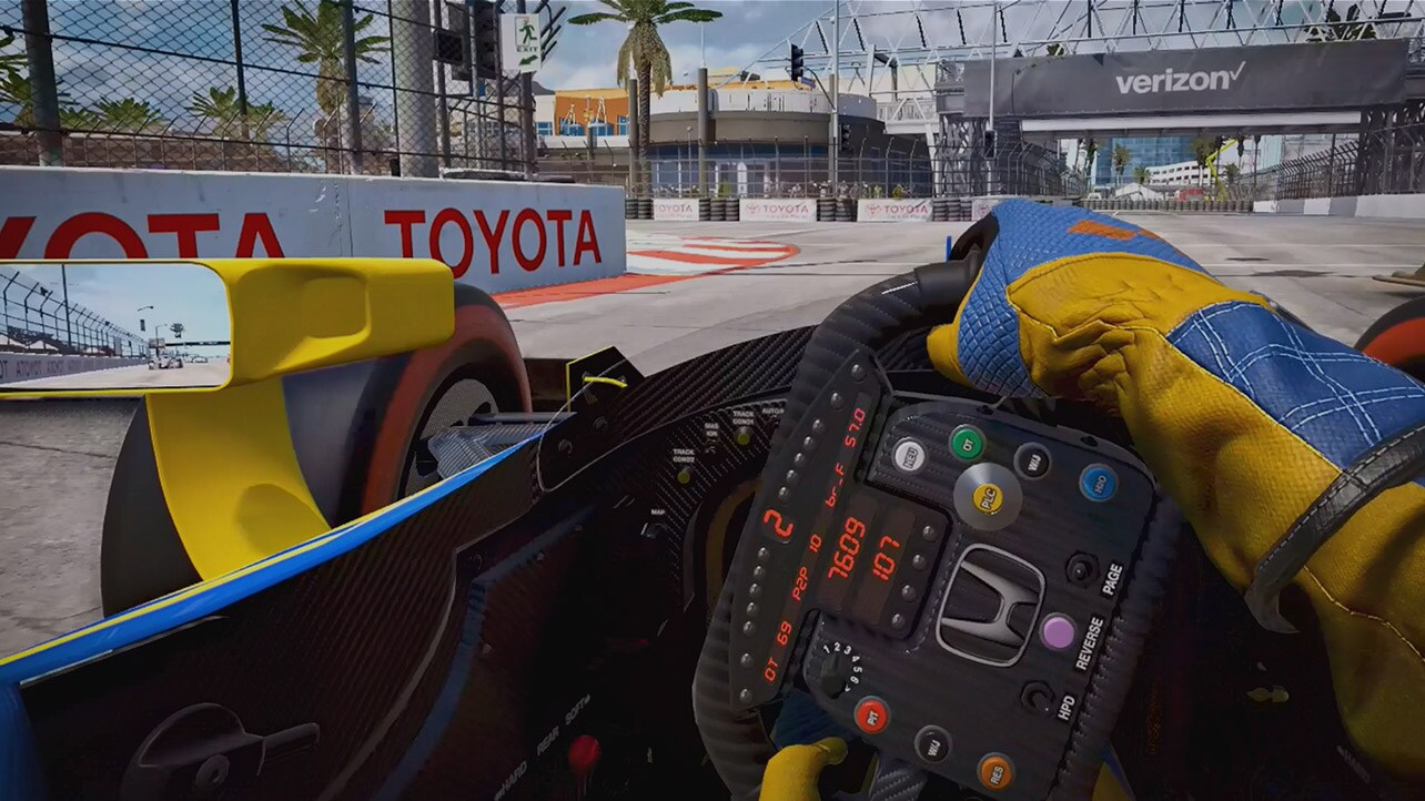 A scene from a racing game with a video play button.