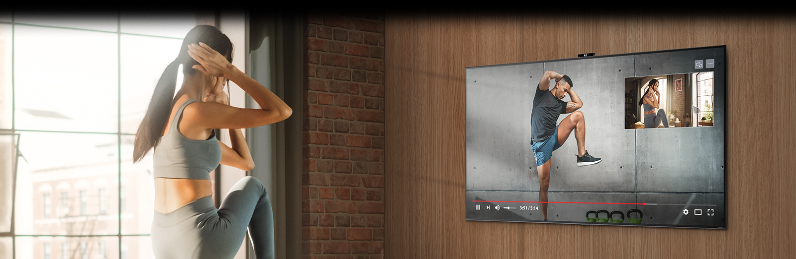 A woman is seen exercising while facing the TV in a home space. On the opposite side of the woman, there is a TV with an LG Smart Cam installed, showing a person teaching and guiding the woman's exercise through the camera on the TV screen.