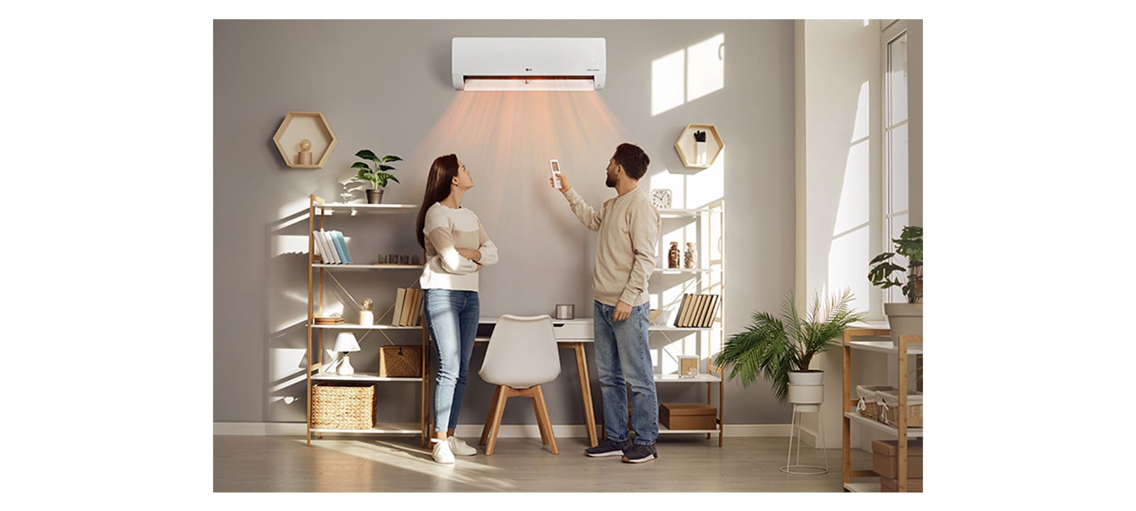 A man and a woman are blown by a warm wind in front of a heater