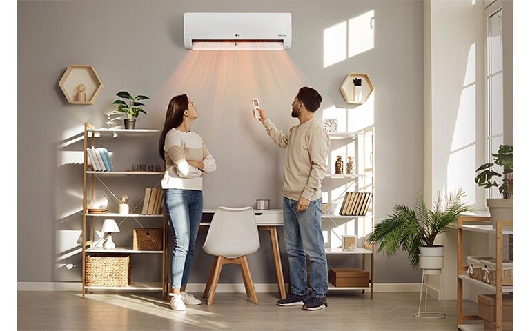 A man and a woman are blown by a warm wind in front of a heater