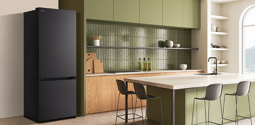 The side view of lg bottom freezer refrigerator with water dispenser with green cabinets and a stylish island.