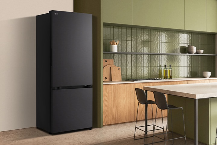 The side view of lg bottom freezer refrigerator with water dispenser with green cabinets and a stylish island.