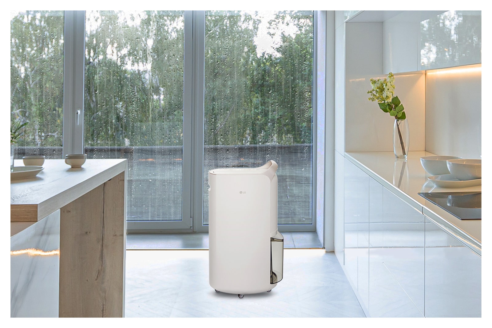 It shows calming beige color LG Puricare™ Dehumidifier is placed in a kitchen with a rainy background.