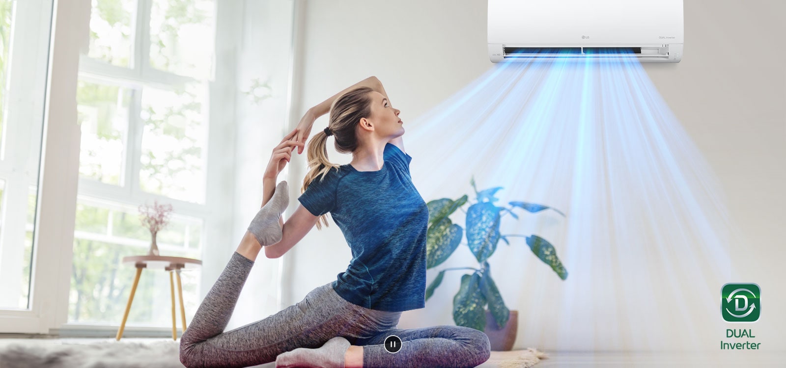 A woman is stretching on the floor. In the background is the air conditioner and blue air flows out over the woman and the room. The Dual Inverter logo is in the bottom right corner.