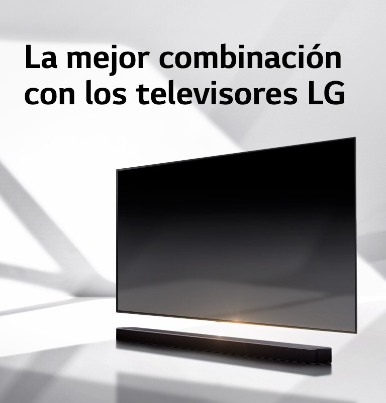 Una barra de sonido y un televisor están situados en un suelo blanco y por detrás aparece una sombra que viene del exterior.