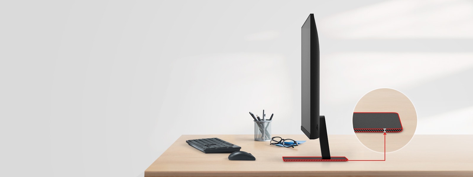 A QHD monitor with a super slim stand is on the desk, with a pencil holder, glasses, a keyboard, and a mouse next to it.
