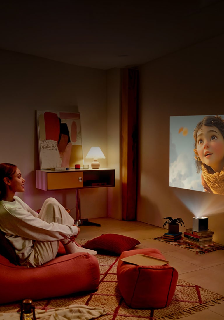 Mujer viendo una película con LG CineBeam.