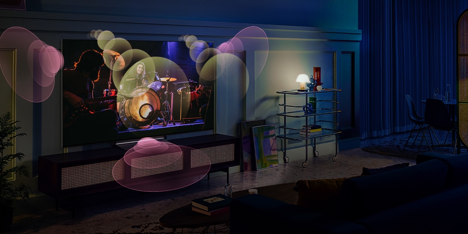 Personas sentadas en un sofá viendo un concierto con burbujas que representan sonido envolvente a su alrededor.