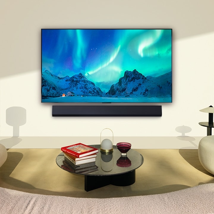 Una imagen de un televisor LG OLED y una barra de sonido LG en un espacio moderno durante el día. La imagen de la aurora boreal se muestra con los niveles de brillo ideales