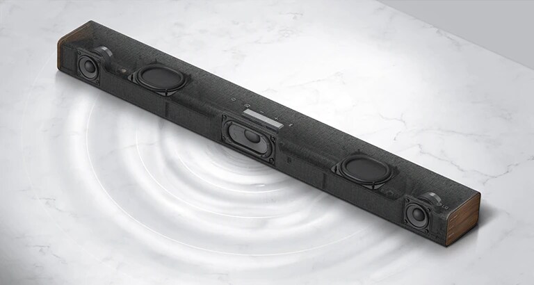 Vista diagonal de la barra de sonido LG transparente con el lado derecho hacia adelante. Se muestran el subwoofer incorporado y los radiadores pasivos duales dentro de un producto y el gráfico de la longitud de onda se muestra en un piso de mármol blanco