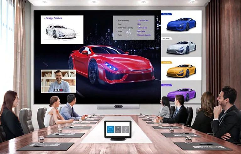 Personas en una conferencia con el MAGNIT y hay un controlador AV en el escritorio.