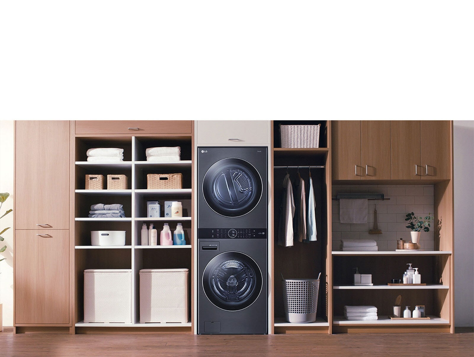 Una Torre de Lavado LG negra se instala en una lavandería, y una mujer se inclina para apretar un botón de la máquina.