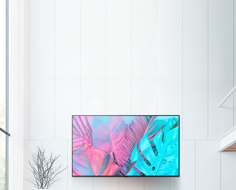 Un gran televisor de pantalla plana montado contra una pared blanca. La pantalla muestra grandes hojas en colores brillantes.