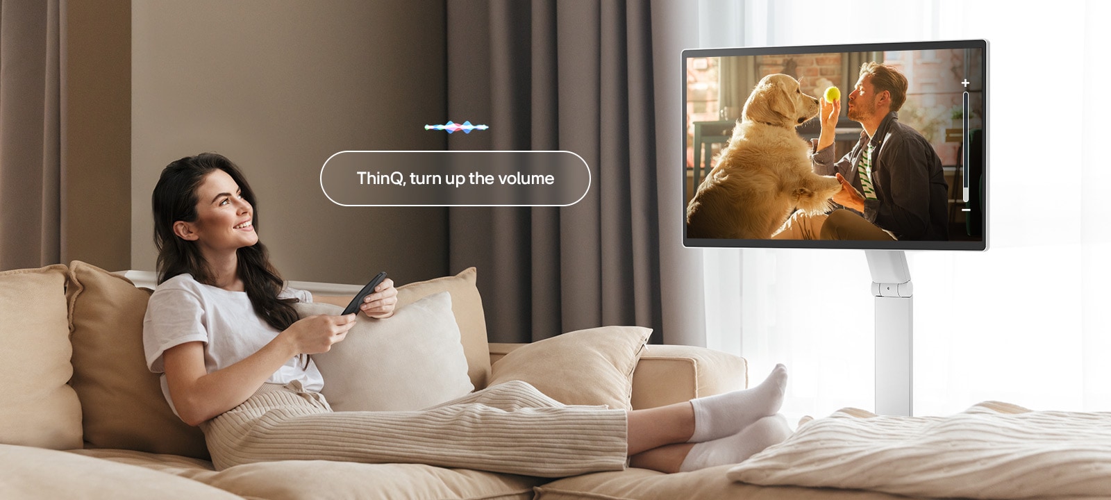 Una mujer está subiendo el volumen del LG Smart Monitor Swing usando un Magic Remote.