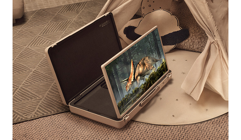 El estuche de la televisión LG StanbyME Go está abierto y la pantalla está desplegada. Dos niños en casa en un campamento improvisado con una tienda y luces cálidas y acogedoras. Están viendo un video en la pantalla de la StanbyME Go.