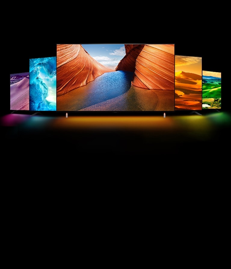 Hay cinco televisores QNED, uno en el medio mirando hacia adelante. Dos se colocan en el lado izquierdo y dos se colocan en el lado derecho. Hay una imagen de un desierto morado en la noche en el televisor de la izquierda, una cueva helada azul en el segundo televisor de la izquierda, acantilados de color naranja en un espiráculo uno frente al otro en el televisor del medio, un desierto amarillo brillante en el televisor de la derecha y un vasto campo verde abierto en el televisor de la derecha. 