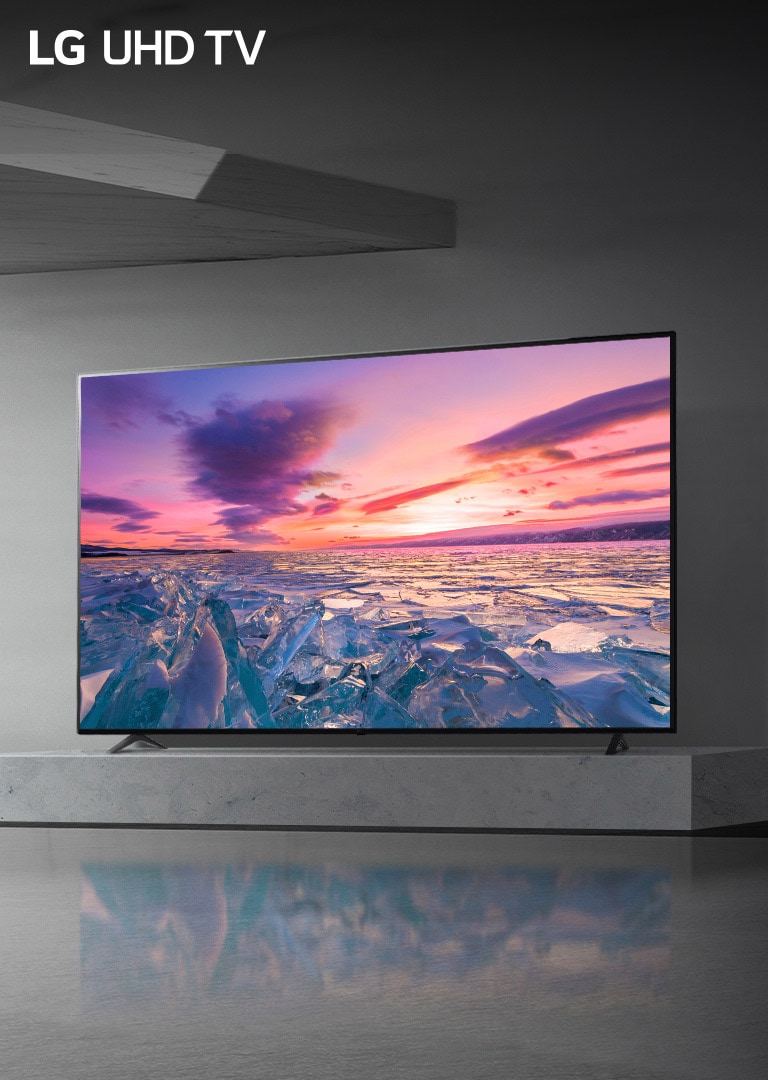 Imagen de un LG UHD AI THINQ TV colgado de una pared con la imagen de un amanecer entre glaciares
