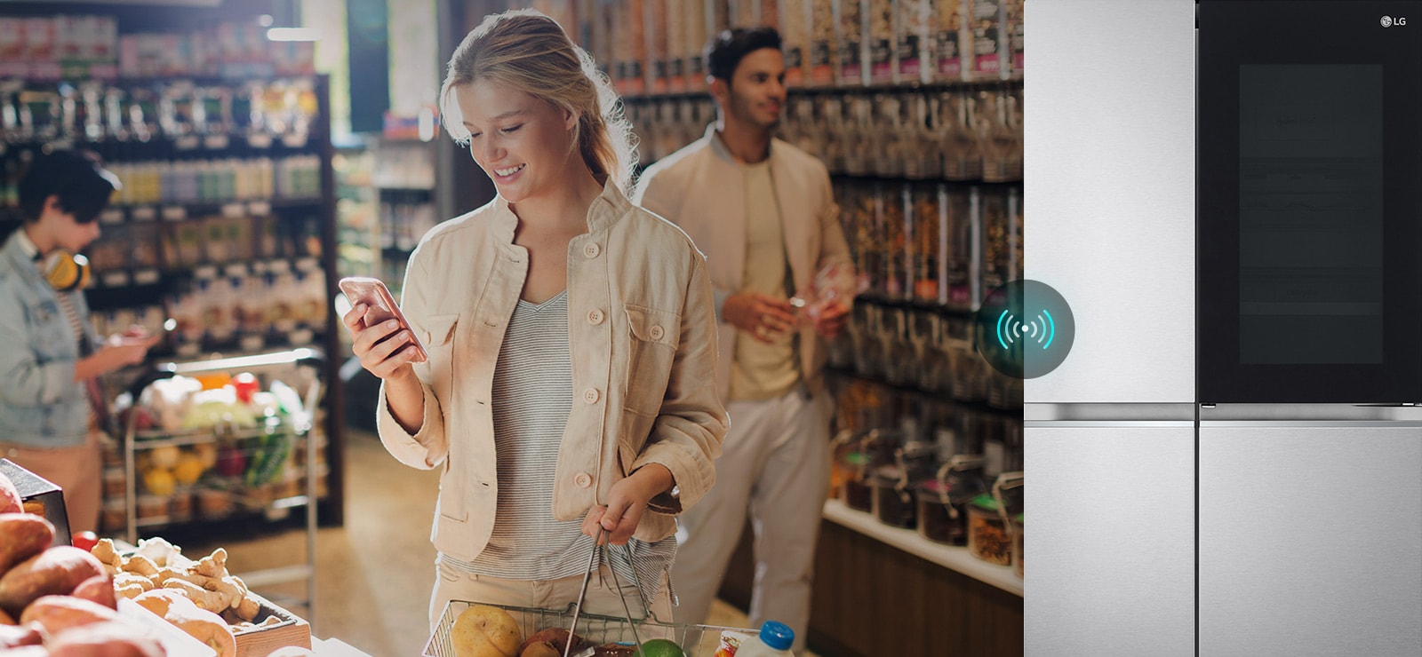The image on the left shows a woman standing in a grocery store looking at her phone. The image to the right shows the front view of the refrigerator. In the center of the images there is an icon to show the connectivity between the phone and the refrigerator.