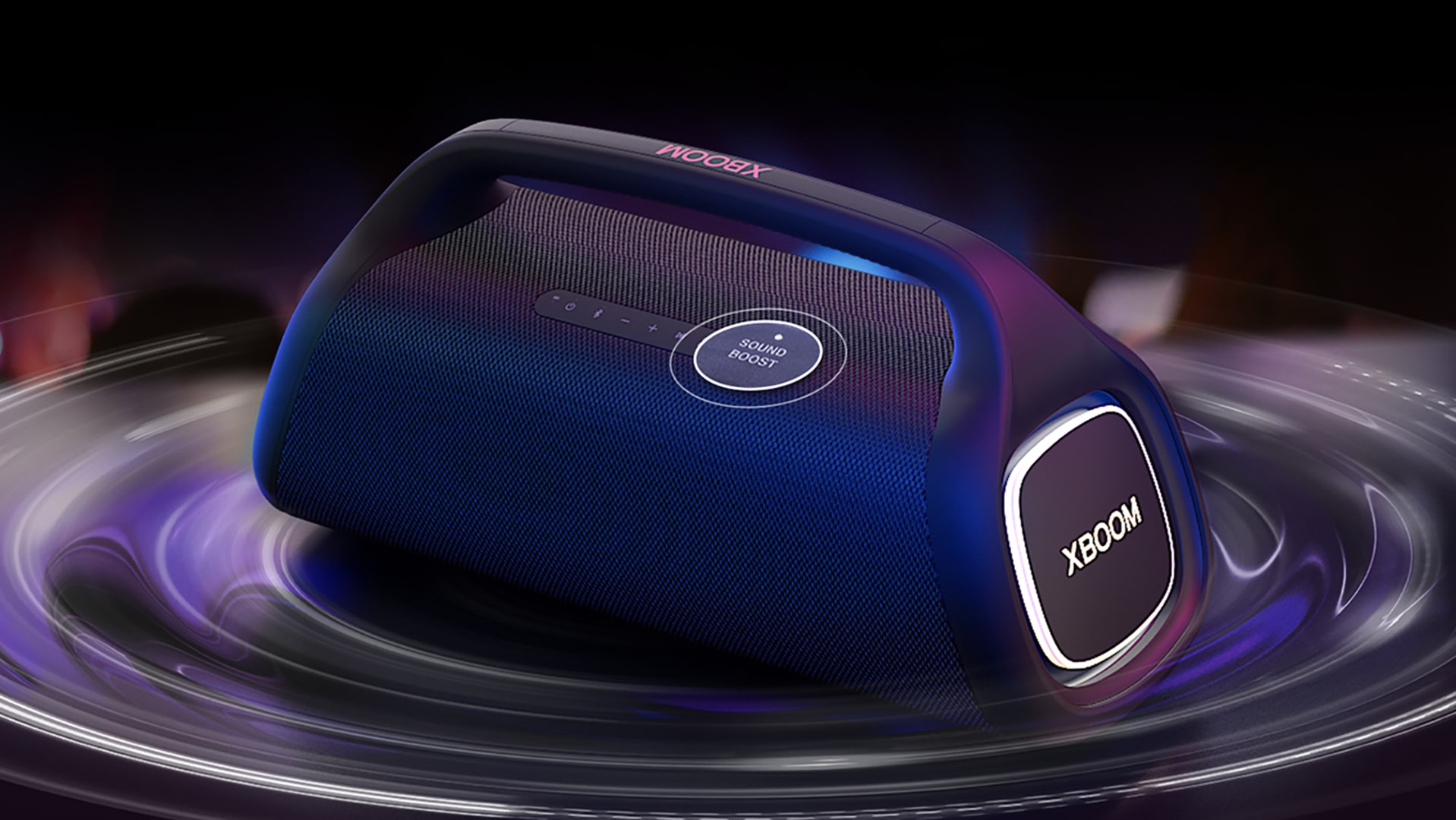 LG XBOOM GO XG9 está sobre la mesa. El botón del amplificador de sonido aumenta y los efectos de onda de sonido están debajo del altavoz. Reproduce el video.