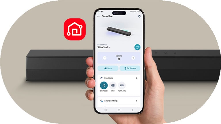 Se sostiene en la mano un teléfono inteligente con la pantalla de la aplicación LG ThinQ. A su lado se muestra el ícono de la aplicación LG ThinQ. Detrás se encuentra la barra de sonido SH5A.