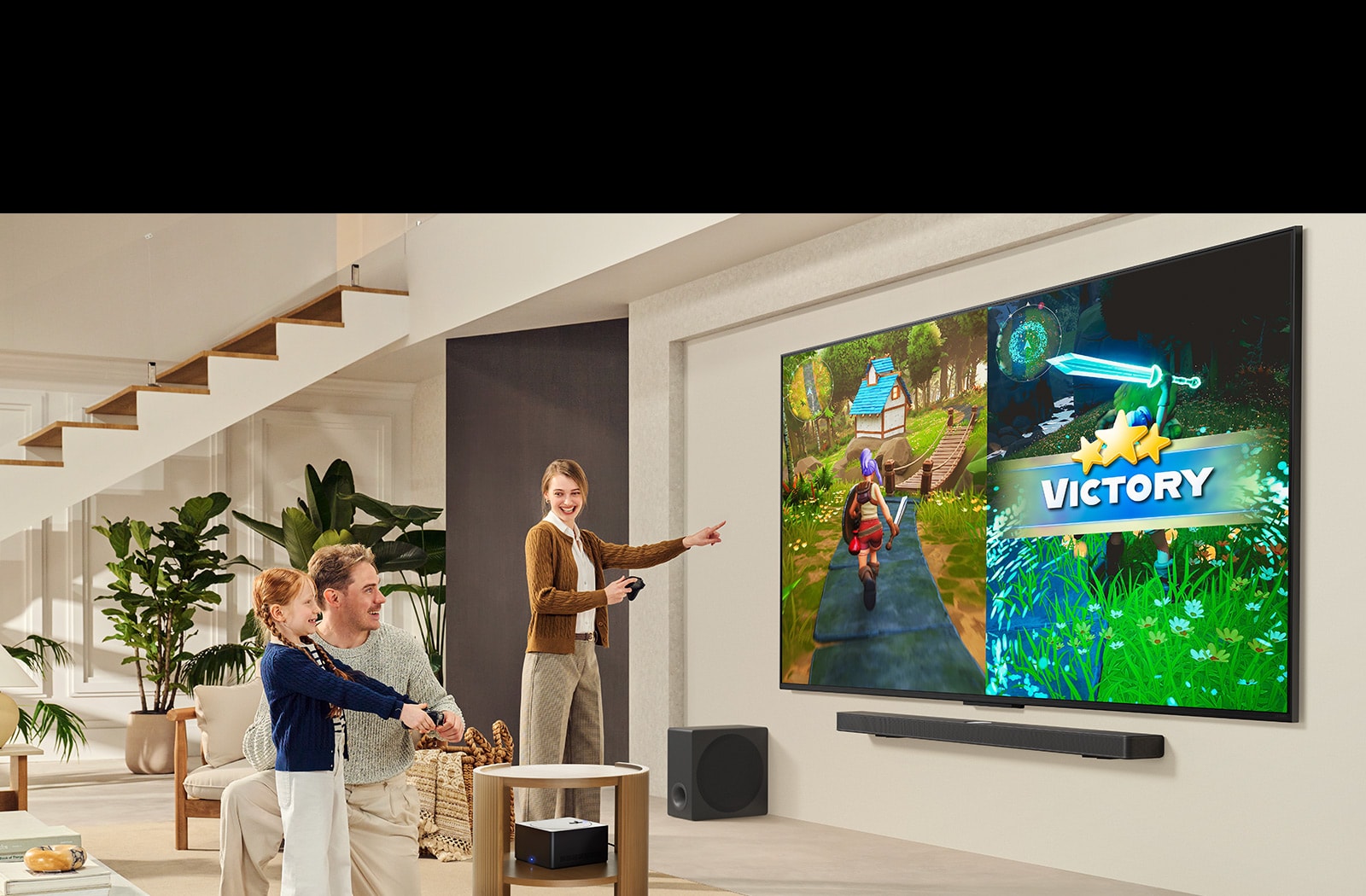 Kolmeliikmeline pere mängib elutoas mängu LG TV teleriga, mis on paigaldatud LG Soundbar ribakõlari kohale seinale. Zero Connect Box asub kohvilaua sees.