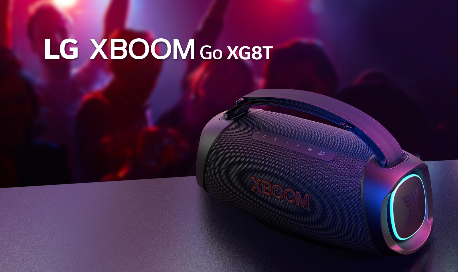 LG XBOOM Go XG8T on paigutatud metallist lauale, kus põleb oranž tuli. Laua taga naudivad inimesed muusikat.