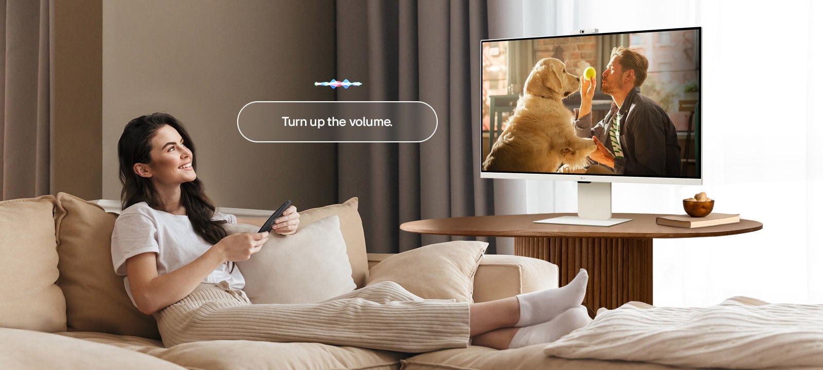 Naine muudab LG Smart Monitori helitugevust Magic Remote’i abil valjemaks.	