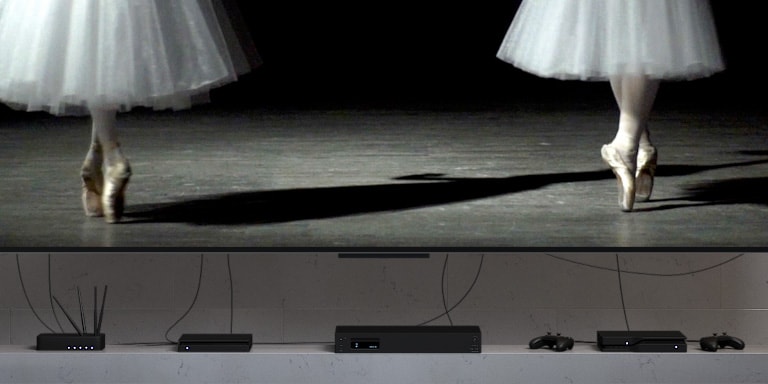 Segane teleri ülesehitus, kõik lisaseadmed teleri all koos paljude juhtmetega. Ülesehitus kaob ootamatult, paljastades LG True Wireless TV. Ei ühtegi nähtavat juhet. 