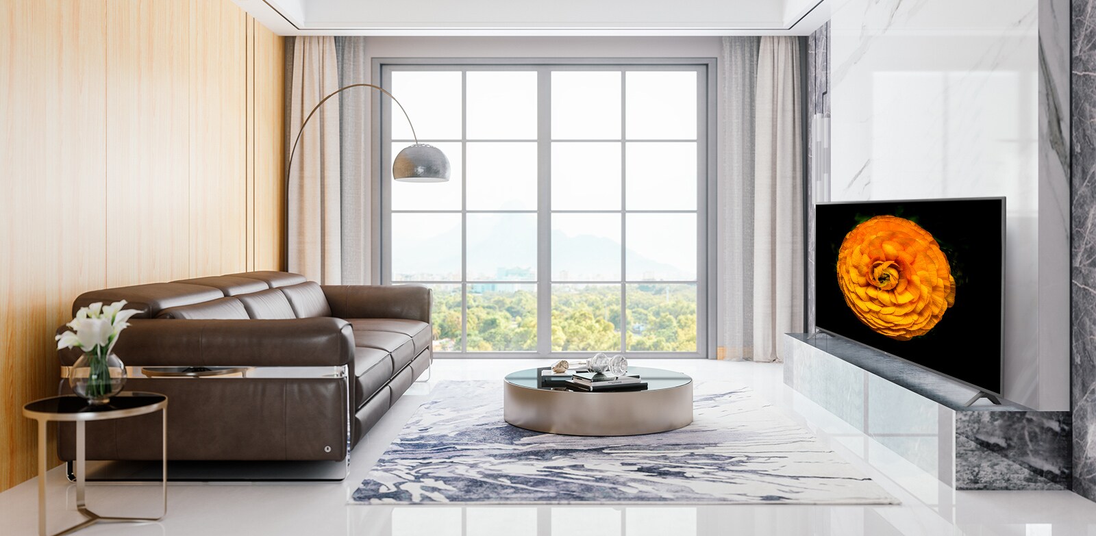 TV LG UHD montata sulla parete di un soggiorno arredato in stile minimalista. Sullo schermo televisivo è presente un'immagine di un fiore.