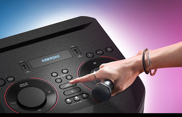 Mikrofoni hoidev käsi püüab LG XBOOMi peal olevat hääle eemaldaja nuppu vajutaad.