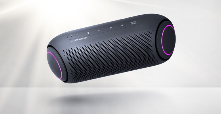 LG XBOOM Go on vasakule kallutatud ja hõljub õhus. Kõlar on magenta valgusega.