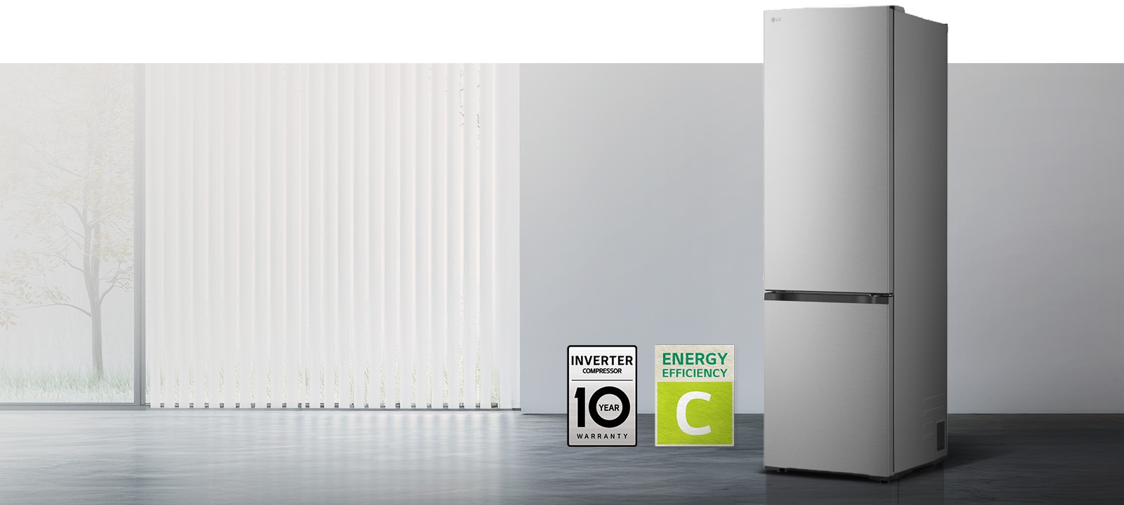 LG alumise sügavkülmaosa (GBBS322CPY) mattmust eestvaade valgusküllases, püstlamellkardinatega toas; allpool on kompressori 10-aastase garantii ja energiatõhususe klassi A ikoonid	