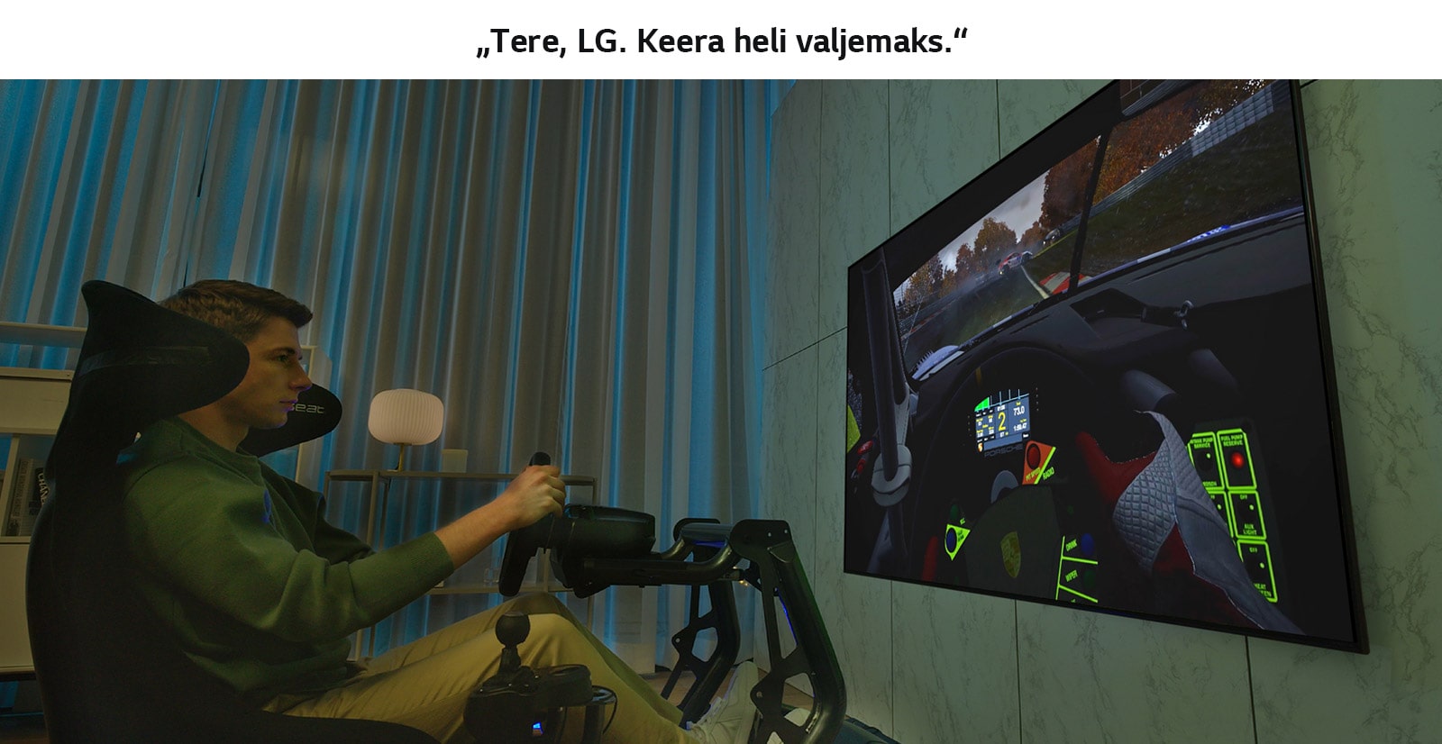 Suure teleri ees rallitoolil istuv ja kihutamismängu mängiv mees.