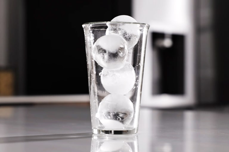 Läbipaistev klaas, täis LG külmkapis valminud ümmargusi käsitööjää Craft Ice kuule