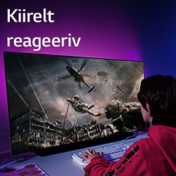 Tüdruk mängib suure ekraaniga teleril arvutimängu , mis näitab helikopterist laskuvat sõdurit.