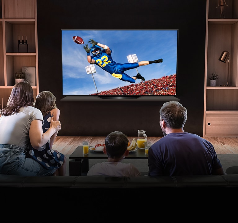 People watching a American football game on TV in the living room