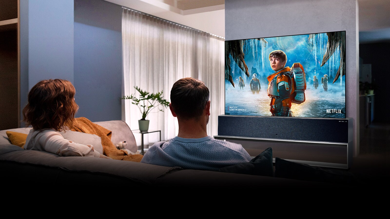 Elutoas diivanil istuv ja telerist armastusfilmi vaatav paar