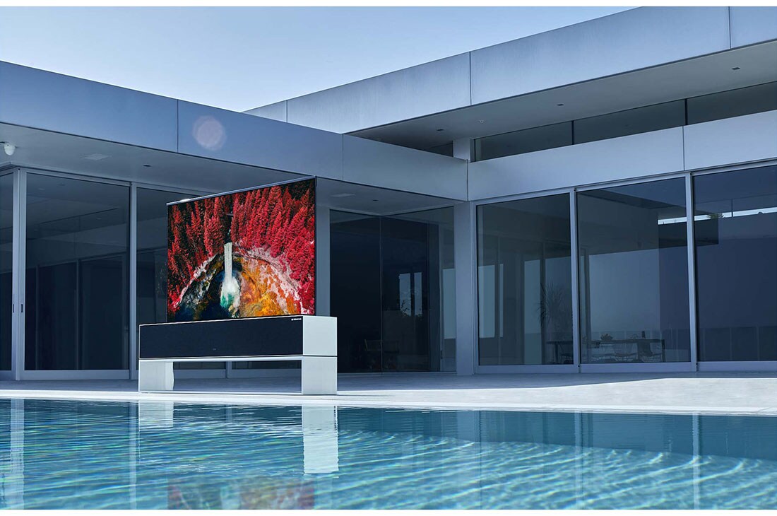 LG 65-tolline OLED 4K teler, Luksuslikus kodus basseini ette paigutatud kokkurullitav teler, mis näitab koske vahtrapuude vahel, OLED65RX9LA, thumbnail 12