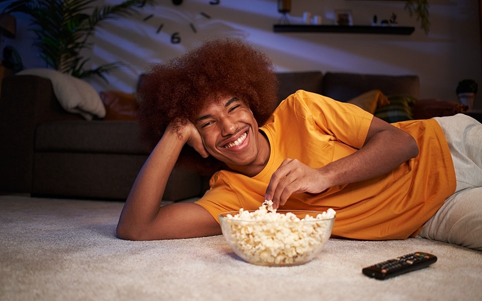 man watching tv with popcorn