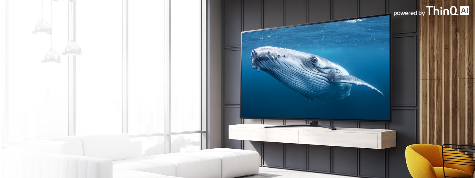 صورة توضح غرفة معيشة بها تلفزيون بشاشة كبيرة يظهر عليها أحد الحيتان الكبير في البحر. يظهر بالصورة الجزء الأمامي من شاشة التلفزيون الكبيرة في منتصف الجزء الأيسر وشعار ThinQ AI في الجزء الأيمن العلوي.