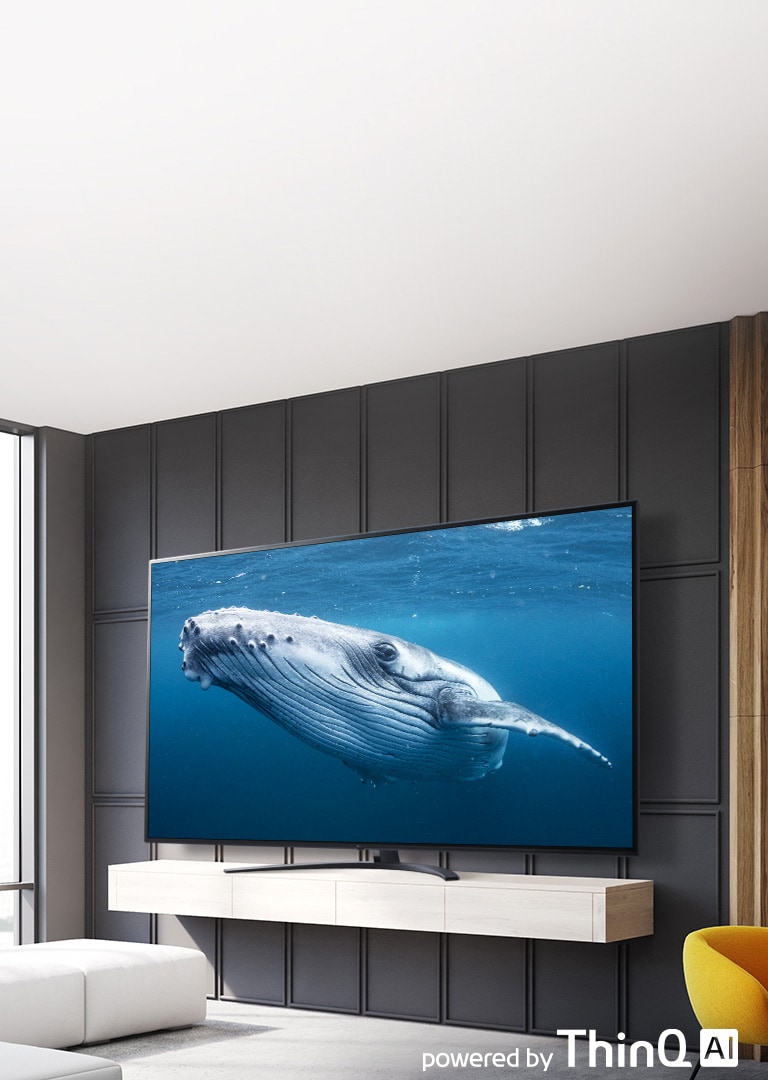 صورة توضح غرفة معيشة بها تلفزيون بشاشة كبيرة يظهر عليها أحد الحيتان الكبير في البحر. يظهر بالصورة الجزء الأمامي من شاشة التلفزيون الكبيرة في منتصف الجزء الأيسر وشعار ThinQ AI في الجزء الأيمن العلوي.