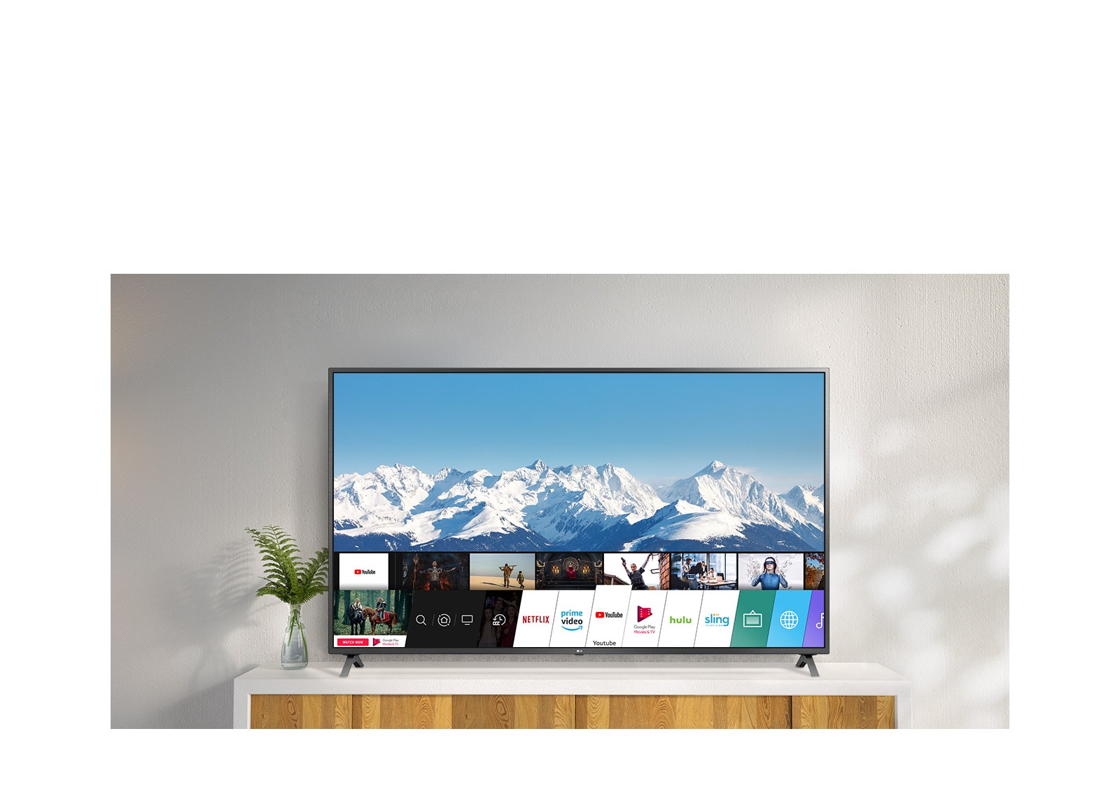 تلفزيون يقف على حامل أبيض مقابل جدار أبيض.  تعرض شاشة التلفزيون الشاشة الرئيسية مع webOS.