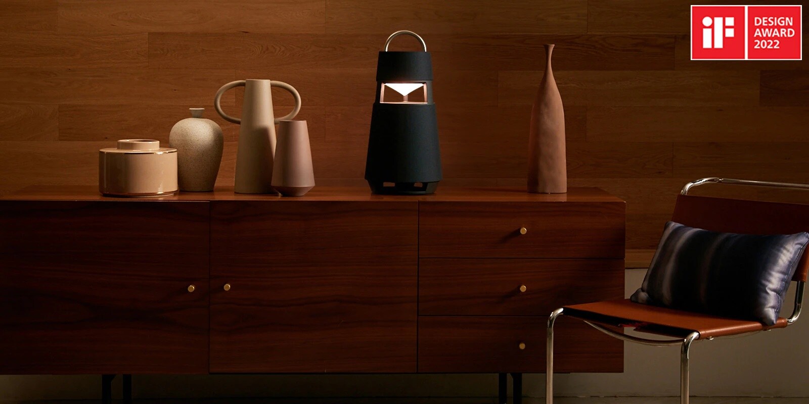 Image of the XBOOM 360 with sculptures on a shelf in a wood-toned interior background.