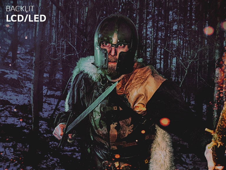 Slider comparison of LCD/LED and LG OLED about a color reproducibility via an image of a man wearing armor in the winter wood