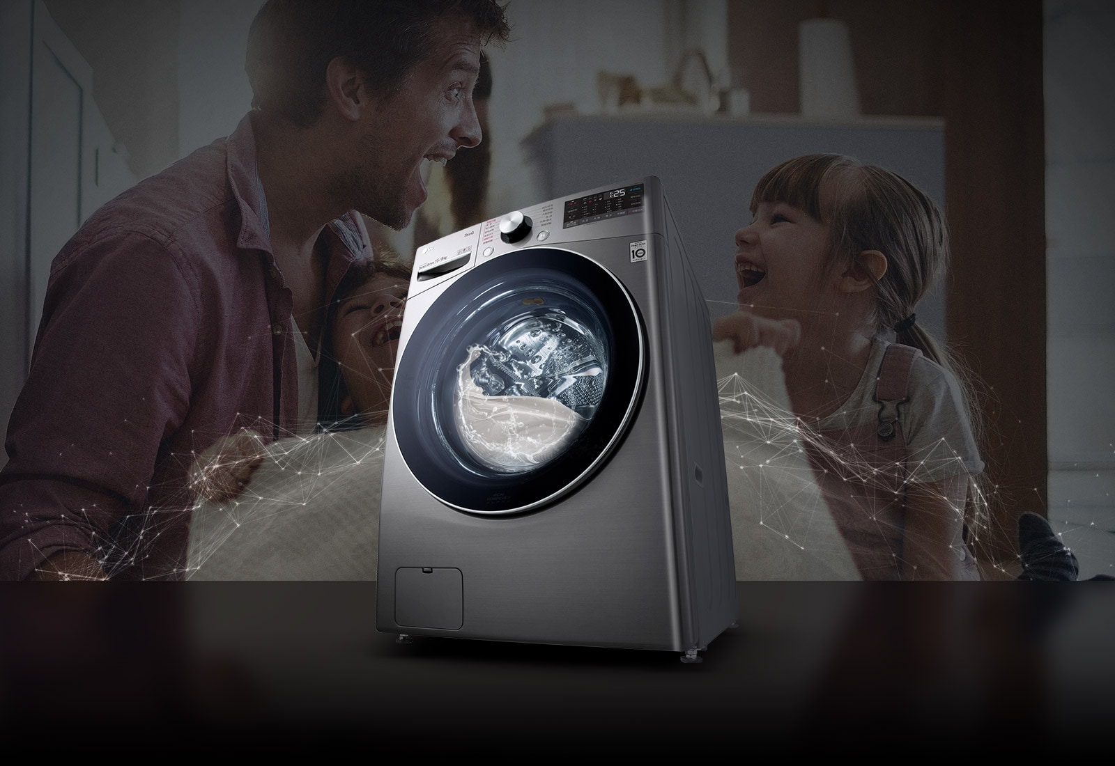 Father and daughters laugh in the background as they hold a clean blanket. A White 76 front load washer in the foreground.