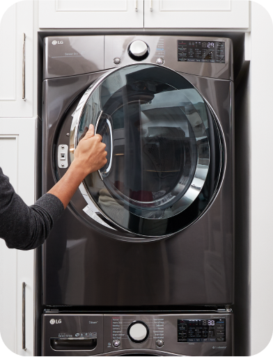 A man is opening the washing machine door.